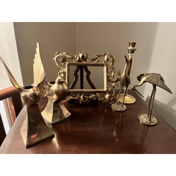 Collection of brass candle holders book end bird sculptures, and a brass picture frame