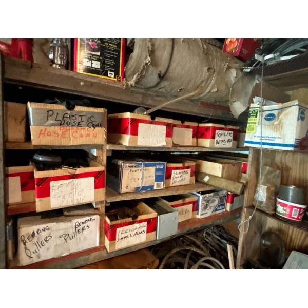 Several labelled boxes with plastic hoses trailer bearings door hardware, pulleys, and irrigation, s