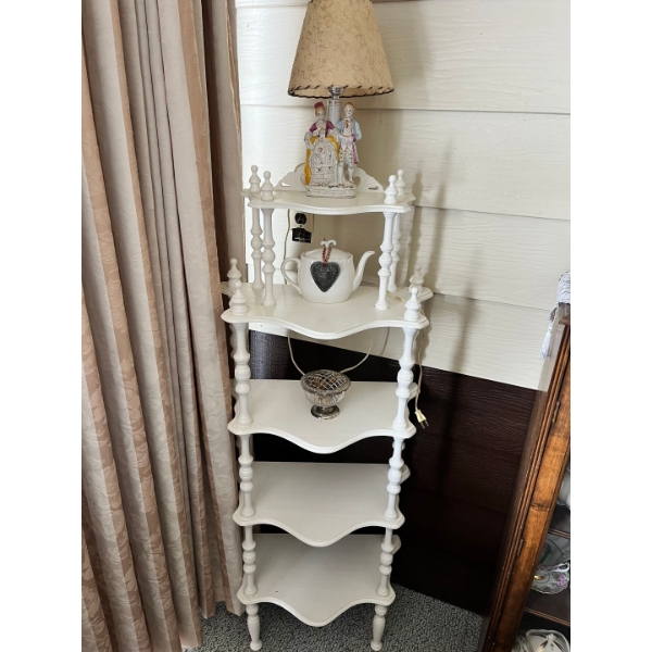 Vintage white corner shelf unit is styled in a French Provincial or shabby chic aesthetic. 