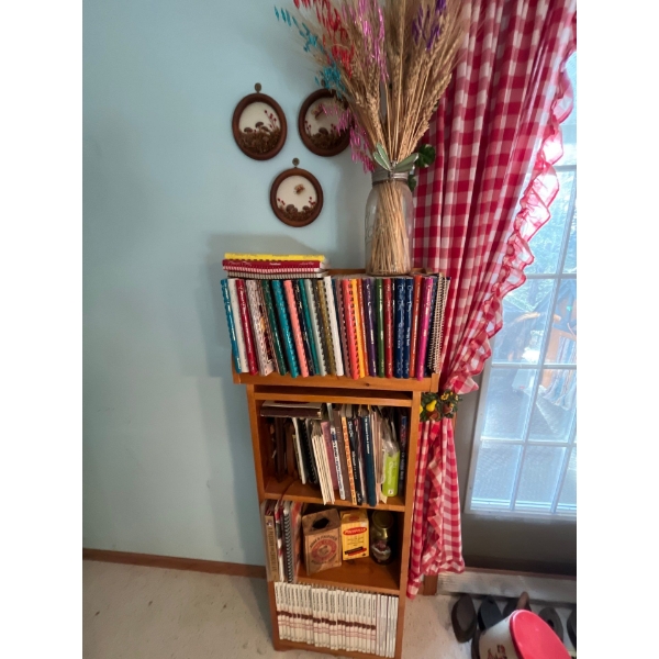  large collection of cookbooks with wooden stand and wall hanger with wheat grass ornament and three