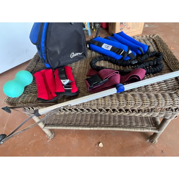  small wicker table with exercises hand weights and a grabber.