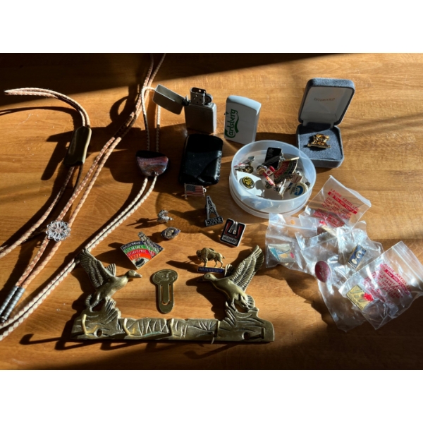Collection of pins from over seas oil projects lighters and leather bolo ties .