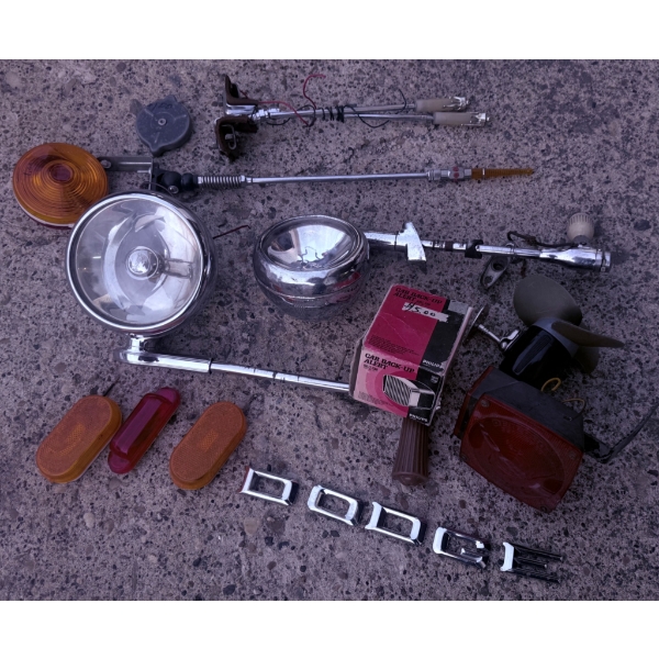 Vintage Automotive Parts Including Spotlights, Antennas, and Emblems