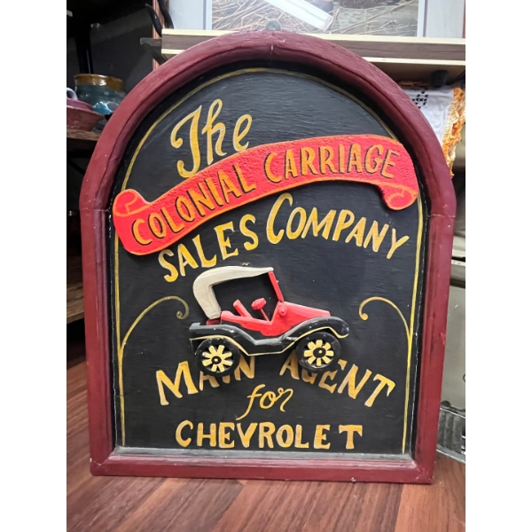 This is a hand-painted wooden sign advertising "The Colonial Carriage Sales Company" 