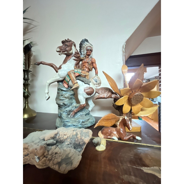 Collection of wood sculptures, including a indigenous man riding on a horse