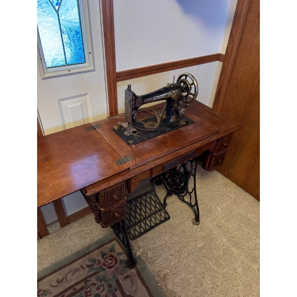 Antique Singer sewing machine, likely manufactured in the early 1900s, housed within its original wo