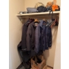 Image 1 : Multiple adult-sized jackets and outerwear on wooden and plastic hangers, along with hats, a sleepin