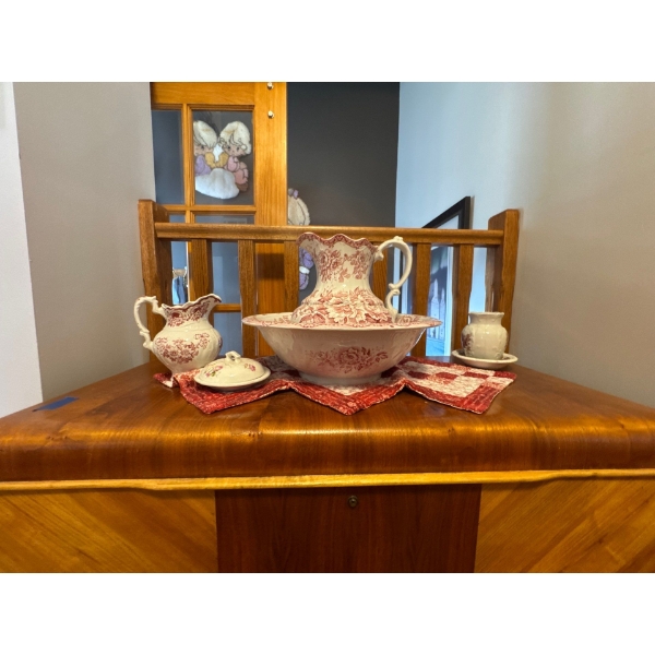 vintage Victorian-style washbasin and pitcher set decorated with a pink transferware floral pattern.