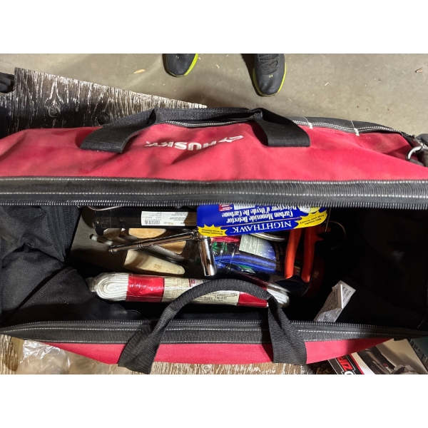 Husky tool bag with various tools, rope, ratchet, snips, spongy cords, trowels, and tools.