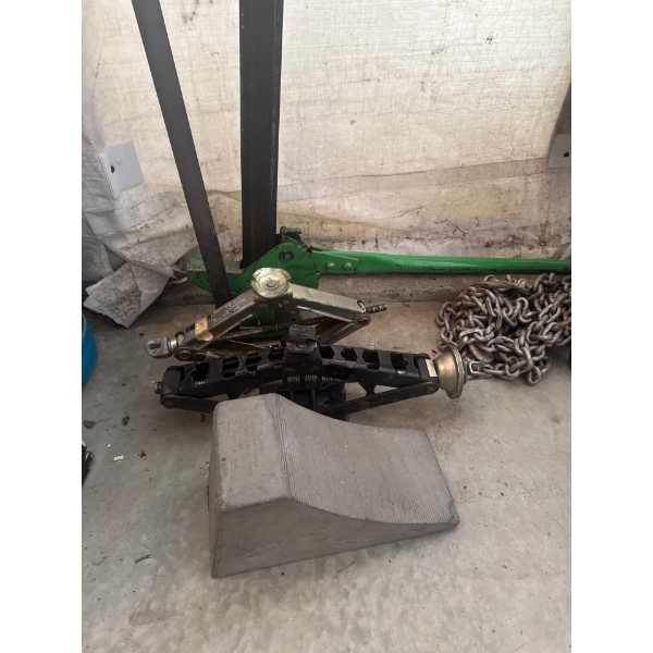 Various floor jacks for jacking vehicles. One large green jack and chain and one wheel chock