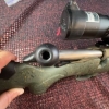 Image 5 : Ruger American bolt-action rifle chambered in 7mm-08 Rem. Features a green speckled synthetic stock,