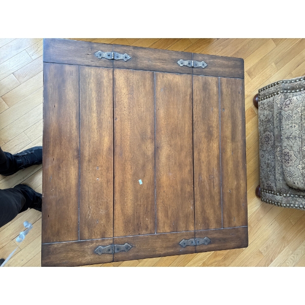  Rustic wooden coffee table featuring a hinged top for storage and metal accents.   