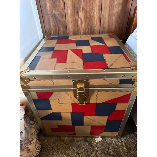 This is a small vintage patchwork leather trunk with brass hardware. It is a decorative storage item
