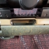 Image 12 : Ruger American bolt-action rifle chambered in 7mm-08 Rem. Features a green speckled synthetic stock,