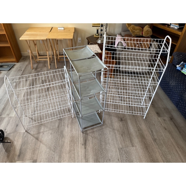 Three white wire shoe racks and one grey cloth rack with 6 cubbies