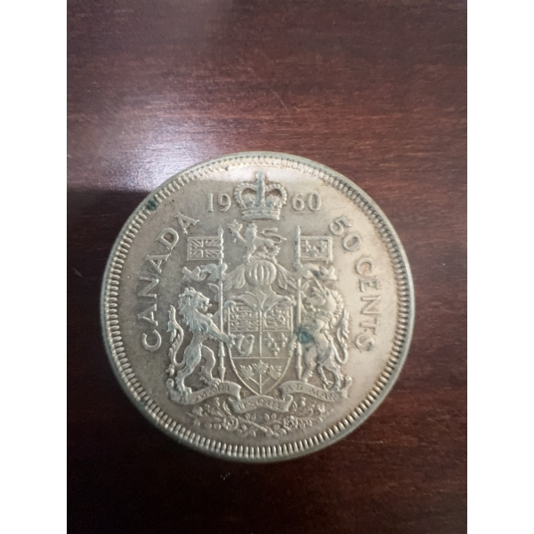 1960 Canadian 50 cent coin featuring the coat of arms and a portrait of Queen Elizabeth II. The coin