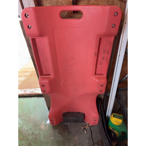 Red plastic rolling creeper with casters, designed for automotive work. Features include built-in ha