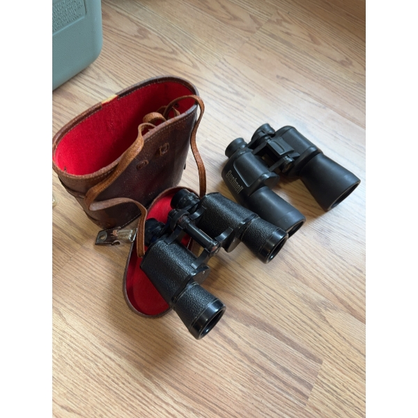 Bushnell binoculars, black finish, featuring textured grip and central focus adjustment. Includes a 