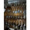 Image 1 : collection of souvenir or collectible spoons on a custom wooden display rack shaped like the contine
