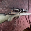 Image 1 : Ruger American bolt-action rifle chambered in 7mm-08 Rem. Features a green speckled synthetic stock,