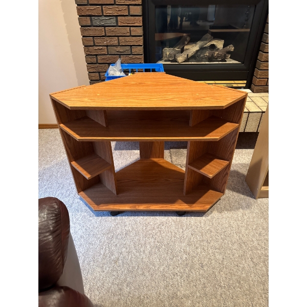 corner television stand is designed for small spaces, featuring a teak finish and a hexagonal shape 