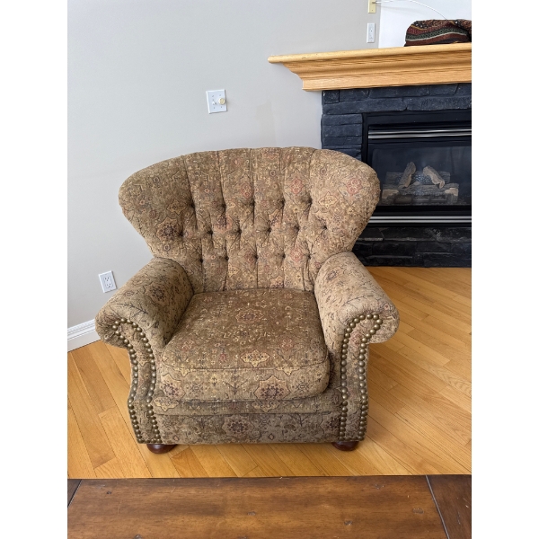  traditional-style armchair featuring a tufted wingback design, rolled arms, and decorative nailhead