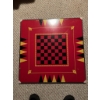 Image 1 : Square wooden game board featuring a central checkerboard in red and black, bordered by backgammon m