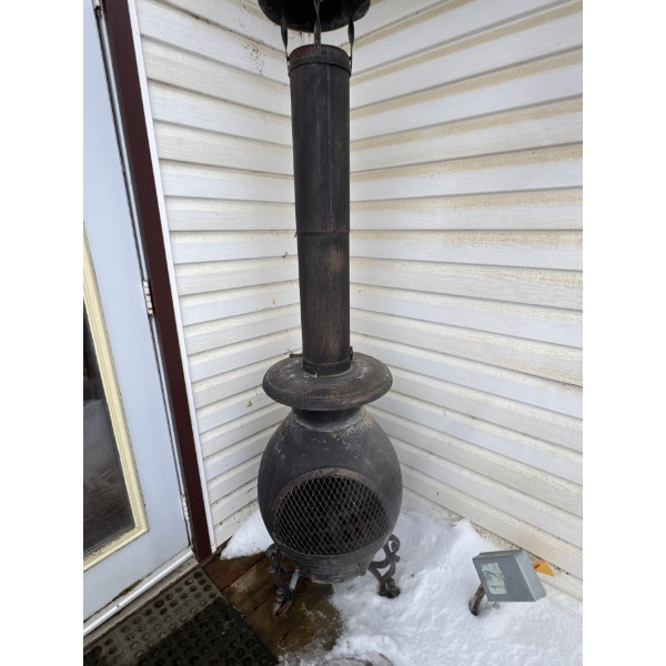 This item is a cast iron wood-burning chiminea, designed for outdoor heating on patios or in gardens