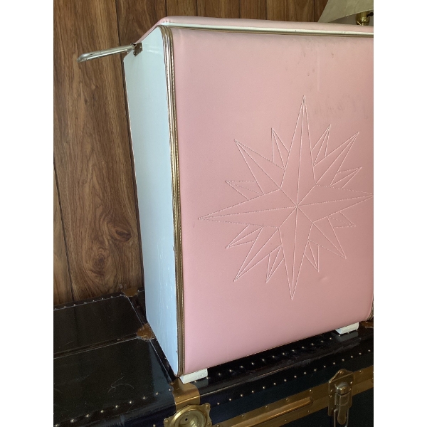 This is a vintage pink vinyl laundry hamper or clothes basket with a decorative starburst design. It