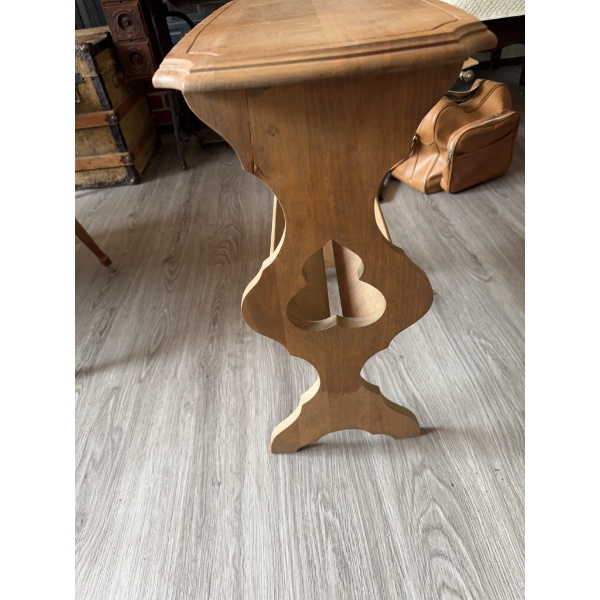 Wooden side table featuring a rectangular top with beveled edges and a decorative cutout base. The t