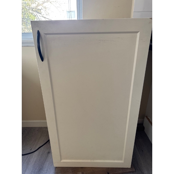 White kitchen cabinet. 23 inches wide by 39 inches high with black curved handle