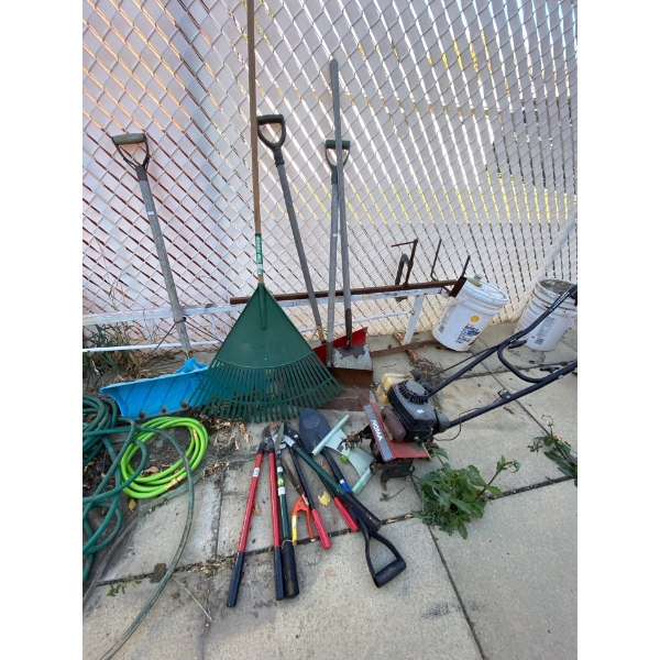  Rototiller and various garden items, including shovels and hoses garbage can and hand made aerator