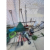 Image 1 :  Rototiller and various garden items, including shovels and hoses garbage can and hand made aerator