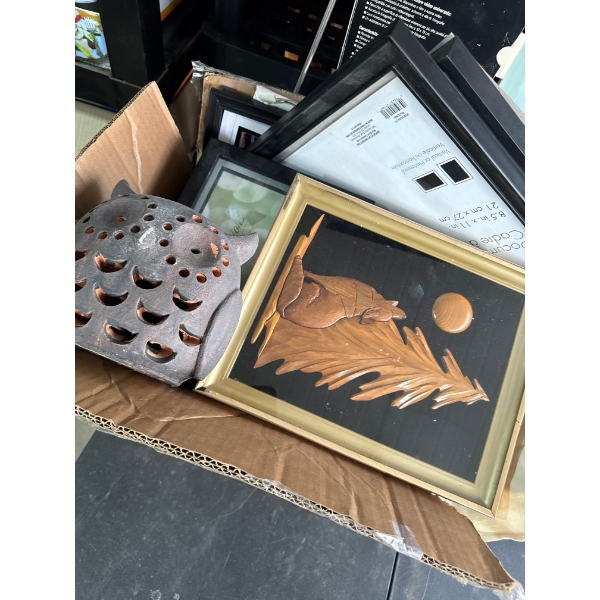 Box full of picture frames and a wooden carving and home decor