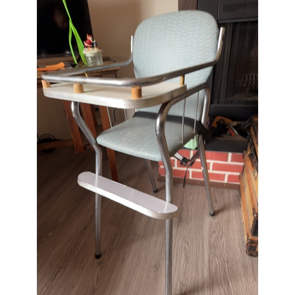 High chair with chrome metal frame, light blue upholstered vinyl seat and back, white footrest, and 
