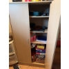 Image 3 : Wooden storage cabinet featuring double doors with metal handles. The interior includes shelving for