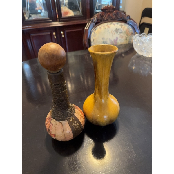 Decorative decanter featuring a ship illustration on the . The neck is wrapped in a dark material, 