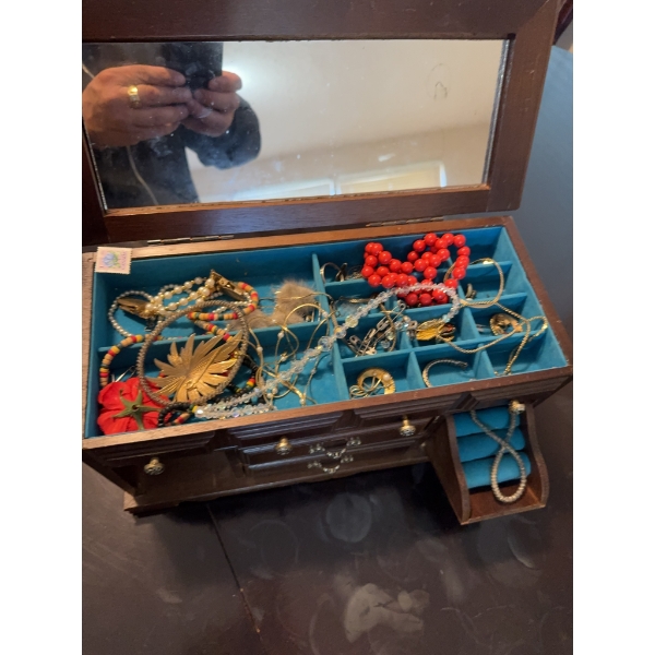 Wooden jewelry box with blue felt lining and divided compartments, containing assorted costume jewel