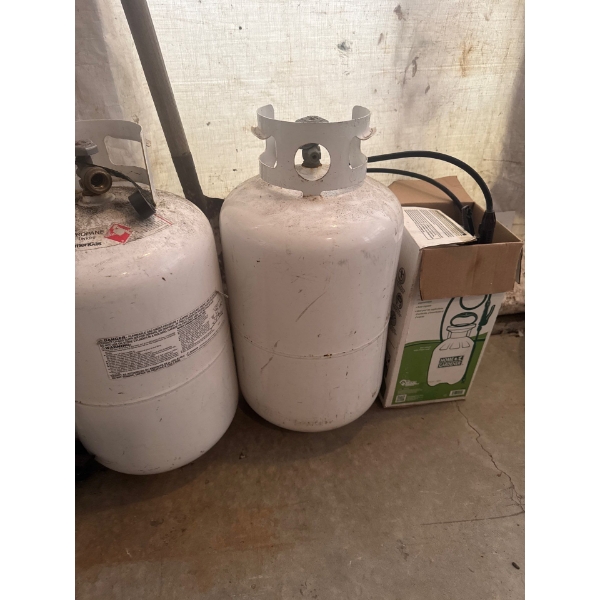 two 30 lb propane tanks, condition unknown, with a home and garden sprayer