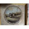 Image 2 : framed circular watercolor painting featuring a rustic landscape scene, possibly depicting a rural b