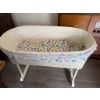 Image 8 : White wicker baby bassinet with folding legs, lace trim, fitted colorful smiley face fabric, and thr