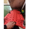 Image 4 : Red plastic rolling creeper with casters, designed for automotive work. Features include built-in ha