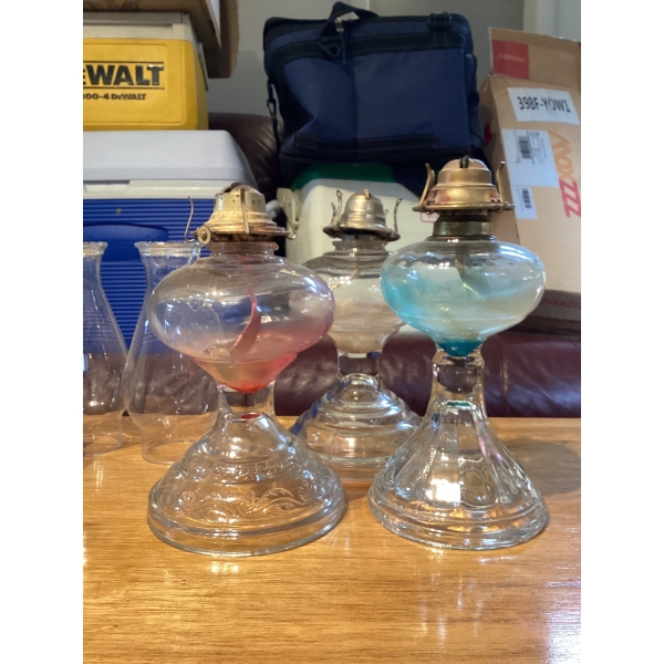 collection of vintage glass oil lamps, also known as kerosene or hurricane lamps. 
Function: These l