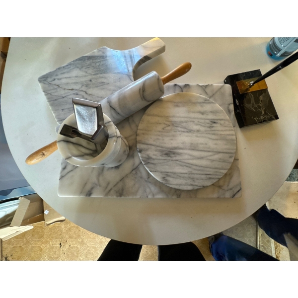 This is a white marble kitchen set, including a rolling pin, cutting boards, and a mortar and pestle