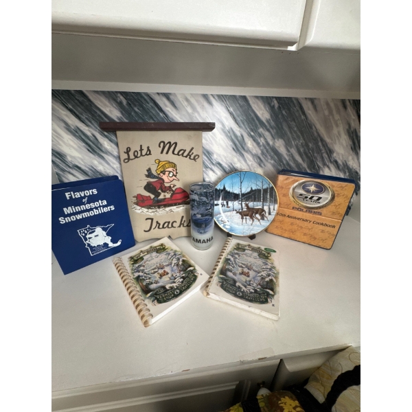 Vintage Polaris and Skidoo collectibles, Yamaha candle holder, cookbooks, and decorative snowmobile 