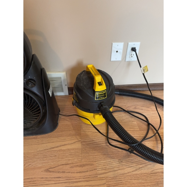 Stanley 1.5 gallon wet/dry vacuum cleaner and a dual-fan portable air circulator. Both items are ele