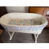 Image 9 : White wicker baby bassinet with folding legs, lace trim, fitted colorful smiley face fabric, and thr