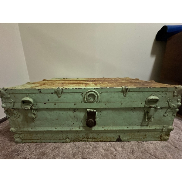This is an antique green painted wood or metal steamer trunk or blanket chest. 