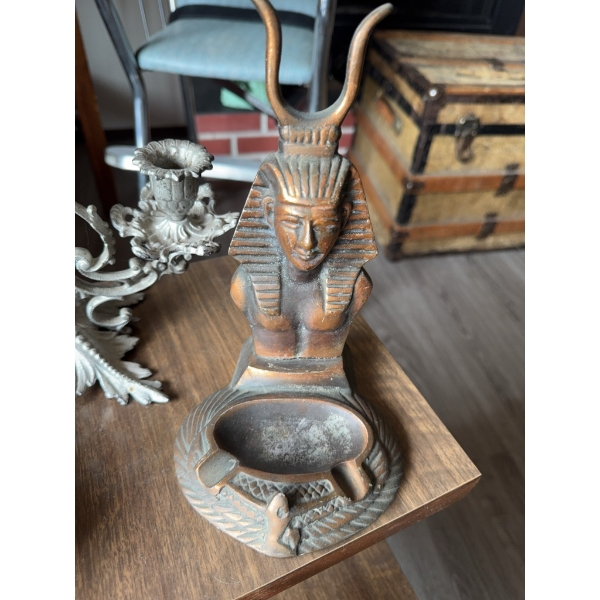 Two glass oil lamps, a metal two-arm candelabra, a ceramic or metal pharaoh-themed ashtray, a glass 