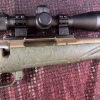 Image 11 : Ruger American bolt-action rifle chambered in 7mm-08 Rem. Features a green speckled synthetic stock,